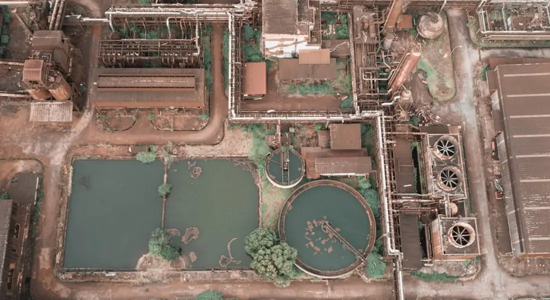 Aerial view of an industrial facility showing interconnected pipes, tanks, and machinery