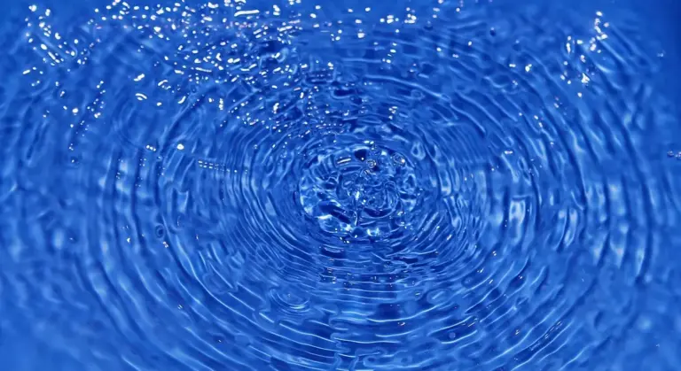 Close-up of blue water with concentric ripples.