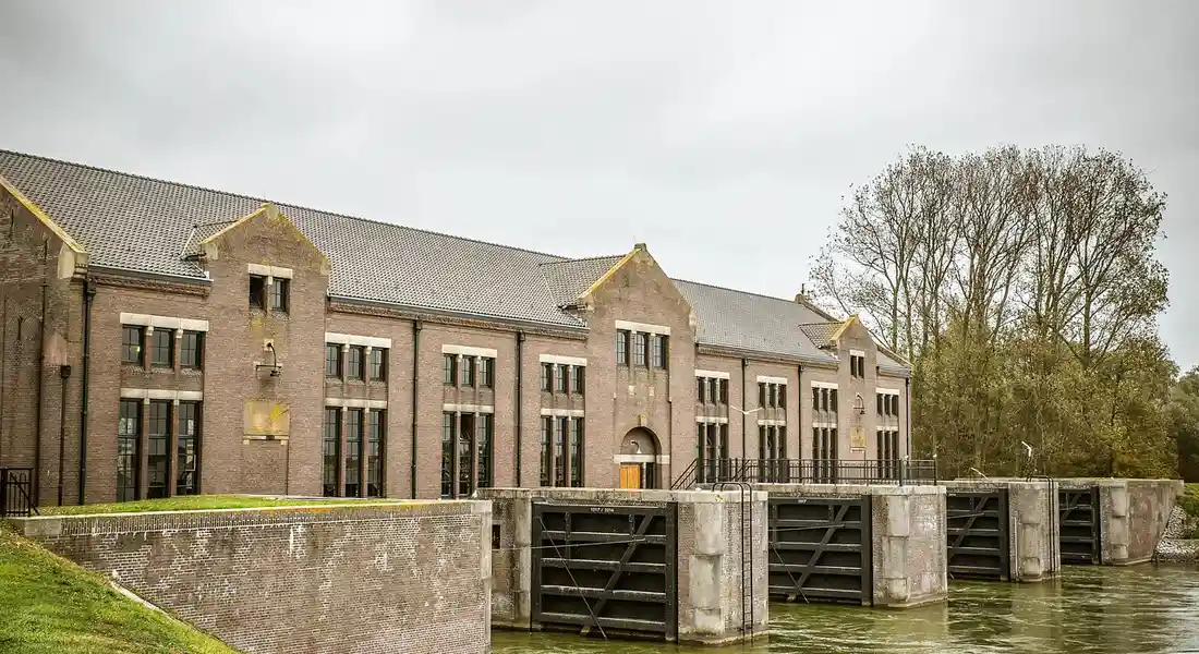 Brick building beside a canal lock with water and lock gates