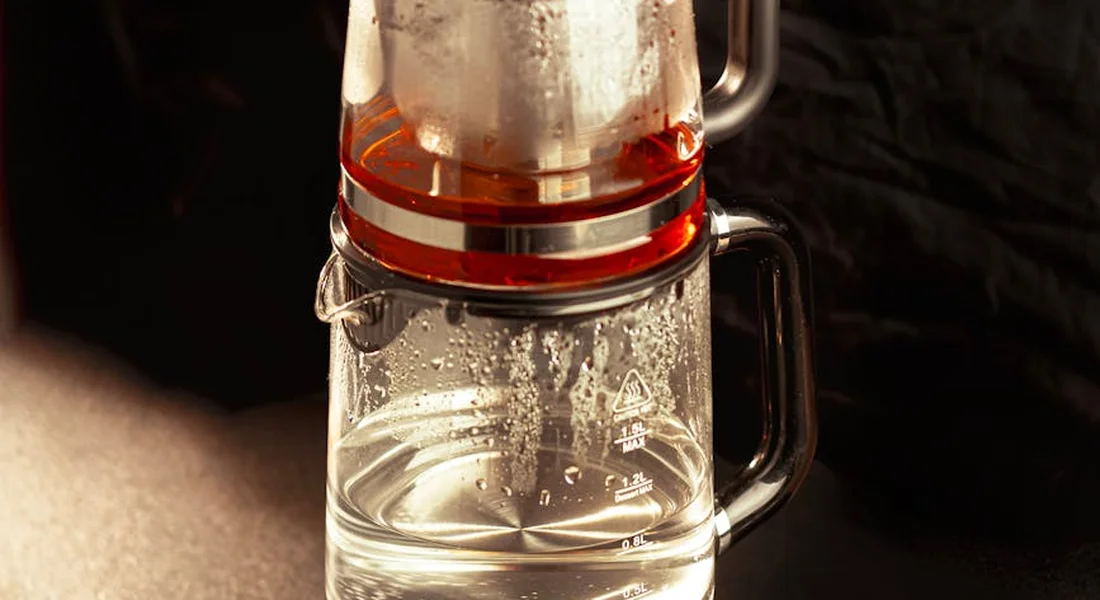 Close-up of a glass coffee carafe with condensation on a coffee maker's heating element