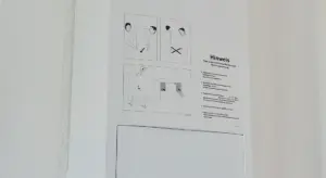 Close-up of a safety instruction label on a white wall with diagrams and the German word 'Hinweis'.