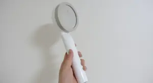 Handheld water testing device being used to check water quality for an aquarium