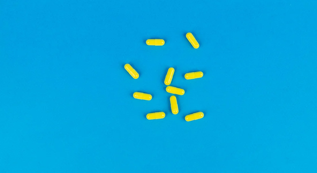 Several small yellow iodine purification tablets scattered on a bright blue background