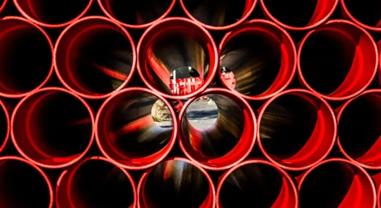 Close-up view of red PEX water pipes with circular openings, ready for installation.