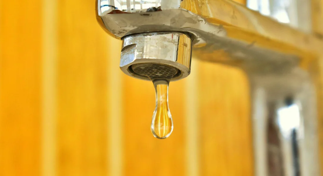 Close-up of a dripping faucet valve, illustrating the need to temporarily cap water supply lines without soldering.