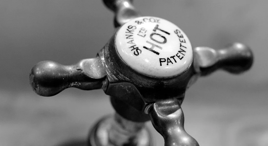 Close-up of a metal plumbing valve handle, symbolizing the transition between PVC and copper pipe connections