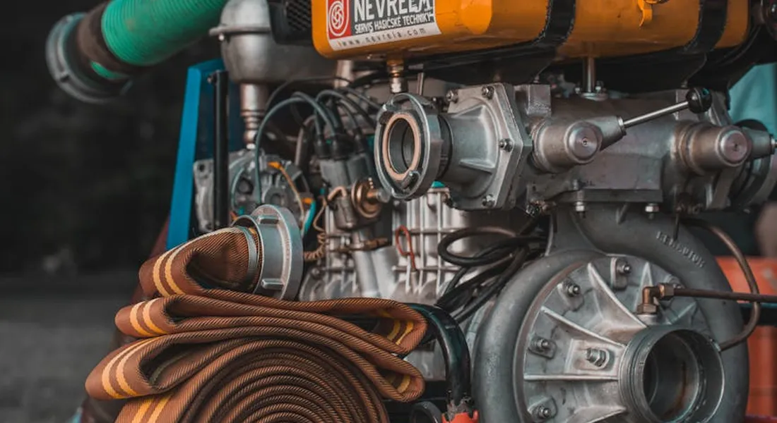 Close-up of a water pump assembly with hoses and mechanical components