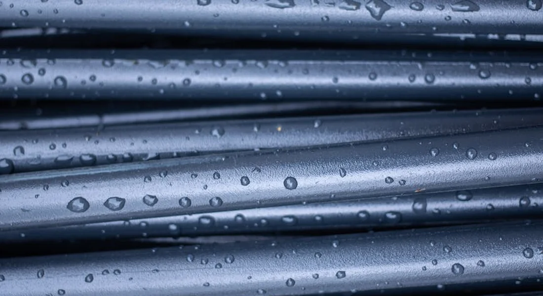 Close-up of metal RV water lines with water droplets, highlighting potential frost-prone spots
