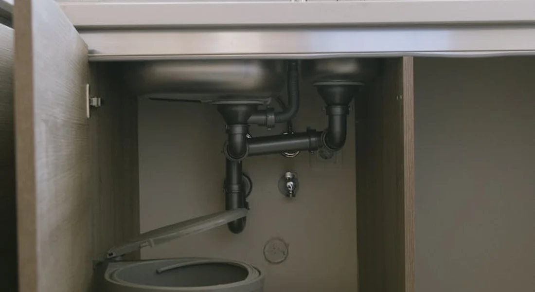 Exposed under-sink plumbing with a P-trap and supply lines, illustrating potential pipe size issues