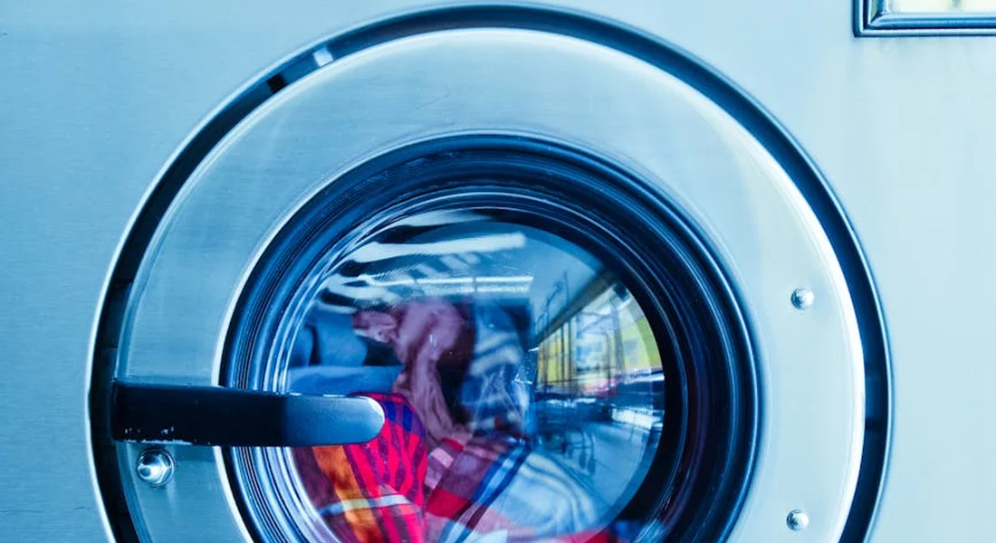 Close-up of a front-loading washing machine door with blue-tinted glass