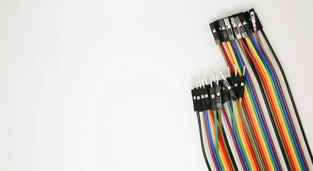 Close-up of multi-colored electrical wires with connectors against a white background, representing wiring for a water heater.