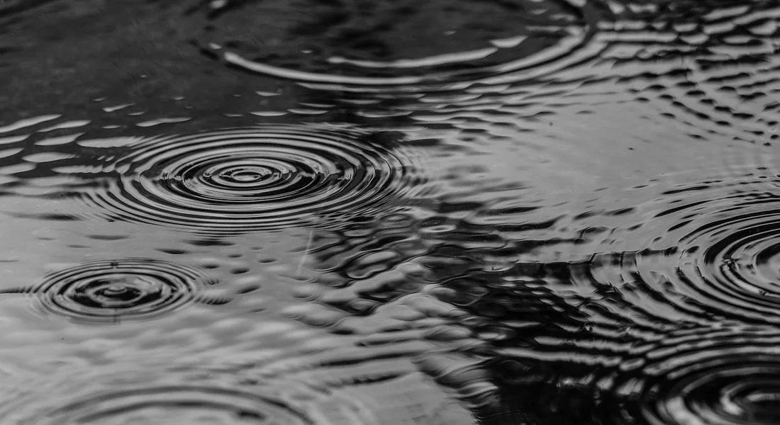 Black-and-white close-up of rippling water surface, representing moisture and leak scenarios