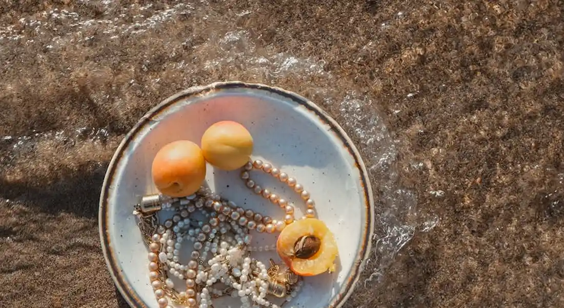 Close-up of resin beads in a small metal dish on a rough surface.