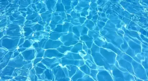 Close-up of clear blue water with sunlight reflections on the surface.
