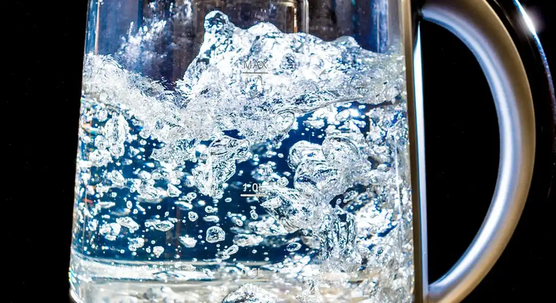 Glass kettle with boiling water and lots of bubbles