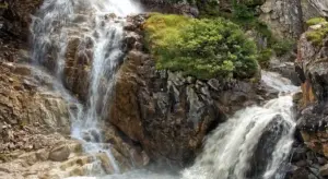 Rocky waterfall with cascading water in a natural setting, used as a visual for discussing water treatment topics.