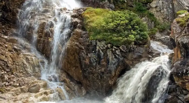 Rocky waterfall with cascading water in a natural setting, used as a visual for discussing water treatment topics.