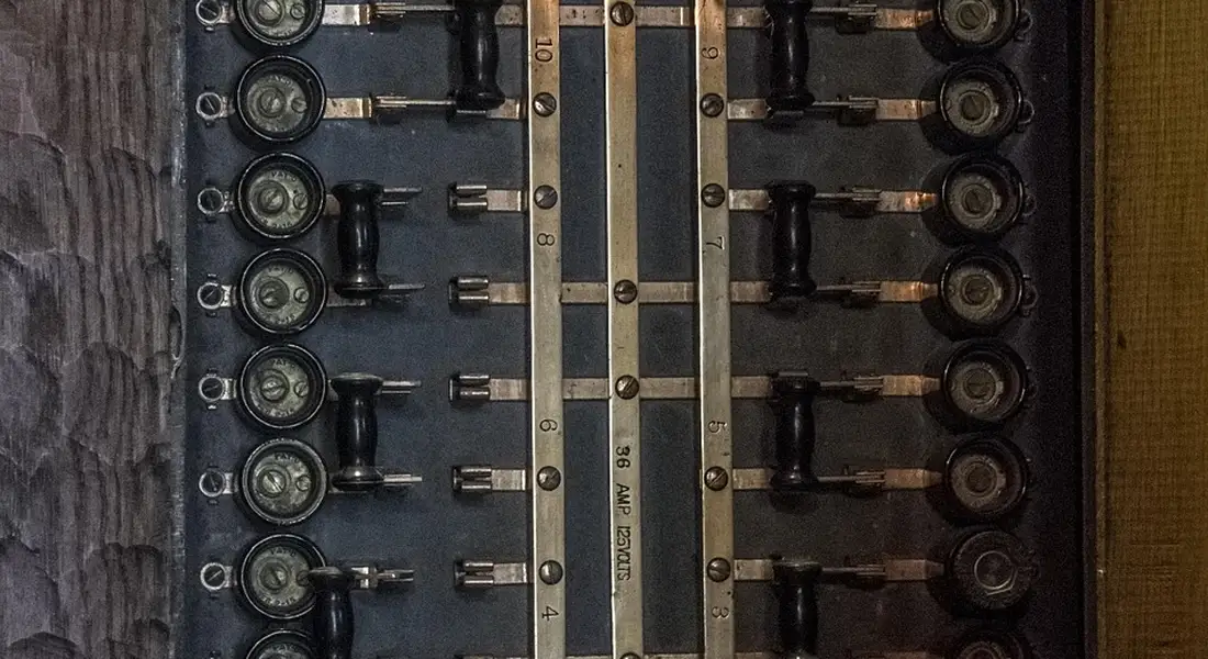 Close-up of an electrical panel with multiple fuse holders and bus bars, illustrating circuit protection components used in well pump wiring.