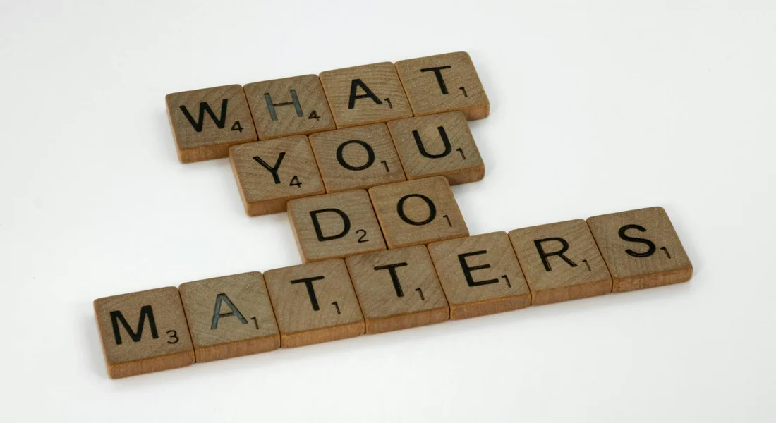 Scrabble tiles spelling 'WHAT YOU DO MATTERS' arranged on a light background.