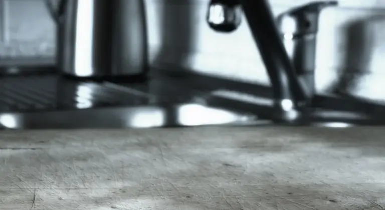 Close-up of a kitchen sink area with a stainless steel faucet and blurred background.