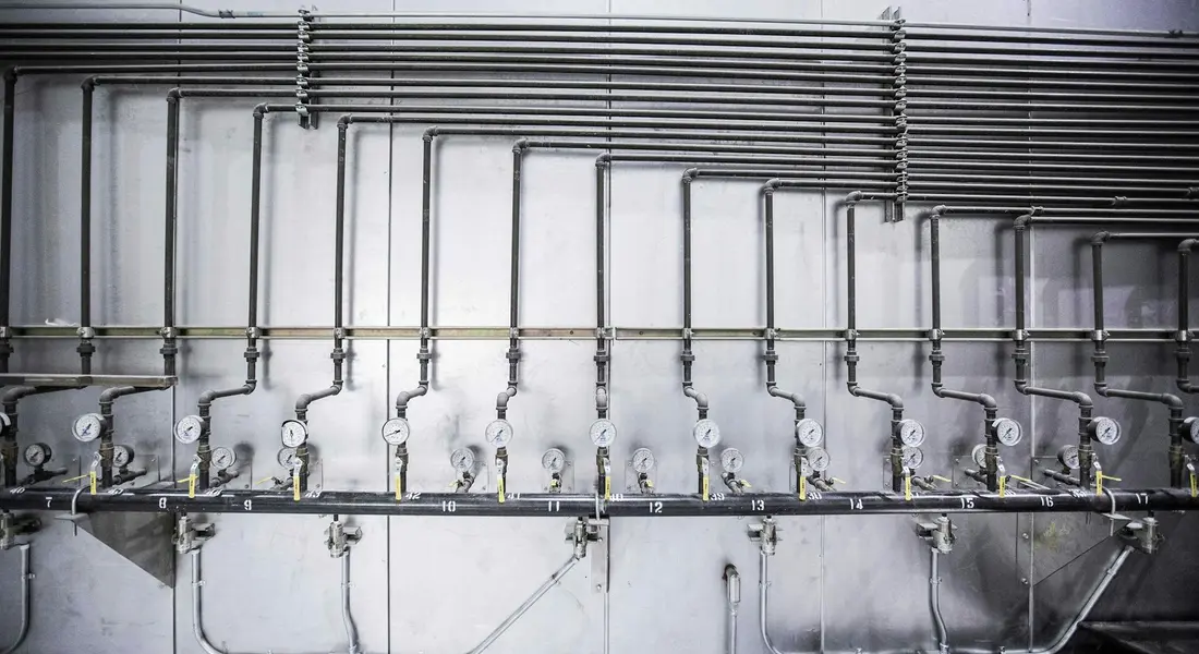 Close-up of a metal pipe manifold with multiple valves and fittings